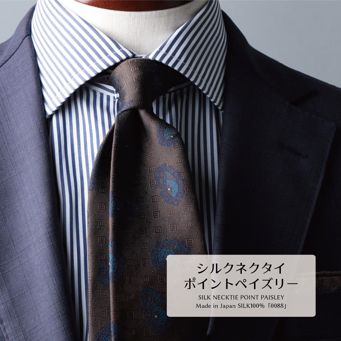 ネイビースーツにロンドンストライプシャツ、ブラウン地にペイズリー柄のネクタイ 。