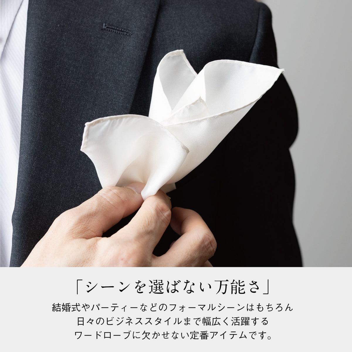 ホワイトのシルクチーフ、ジャケット胸元の結び目風