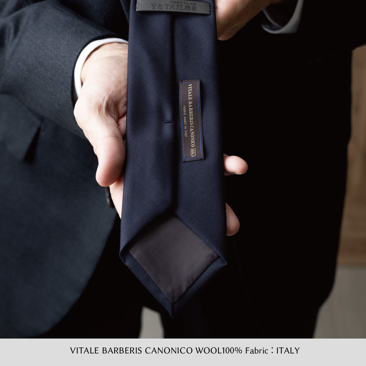 ダークネイビーのウールネクタイ　タグ付き　大剣幅7cm　手に持ったアップ