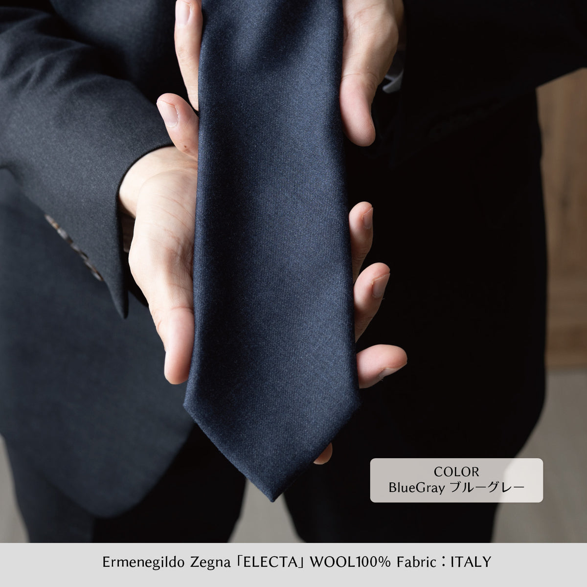 Zegna ELECTA ウールネクタイ（ブルーグレー）のクローズアップ、手でつまんだ状態